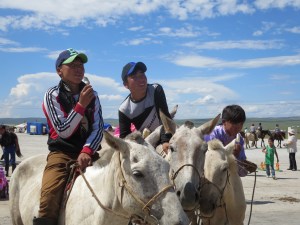 Boys eating ice cream watch the bungee trampoline goers.
