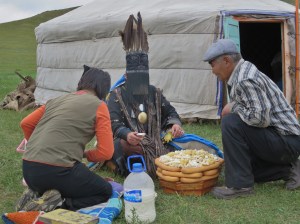 After she settles into a deep trance, her relatives approach here with gits - cheese products and a bottle of airag in the foreground.