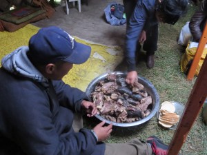 The main dish is served steaming hot inside the ger. Notice that there are a few mats laid down, but otherwise the grassy ground serves as a sufficient floor.