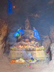 A Buddha statue now sits cross-legged where once a meditator did. Incense and offerings are presented here.